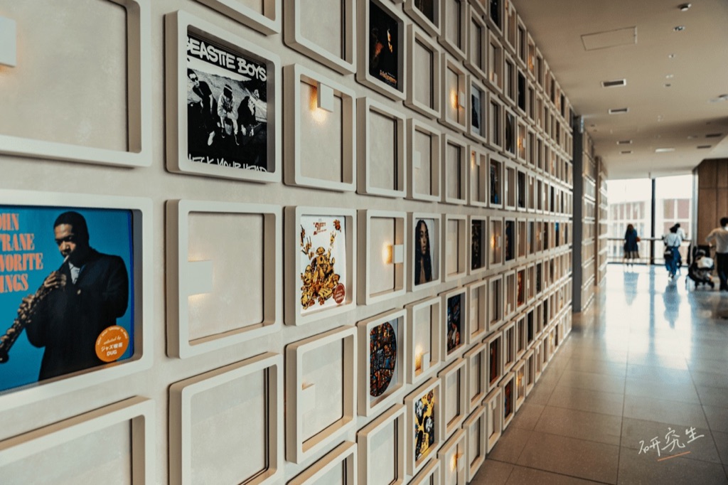 一整面牆的唱片封面展示，走廊延伸到底