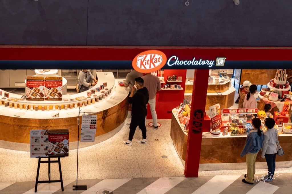 KITKAT Chocolatory 的店面,紅色招牌下是弧形的商品陳列檯
