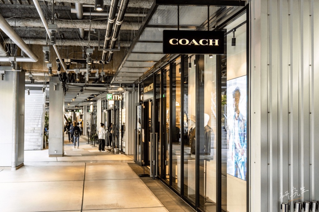一整排路面店的走廊,看得到 COACH 與 KITH 的招牌